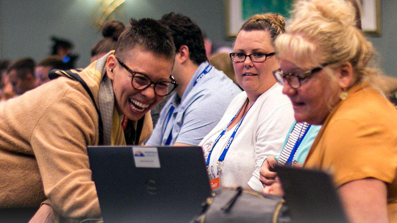 Users and employees looking at a laptop